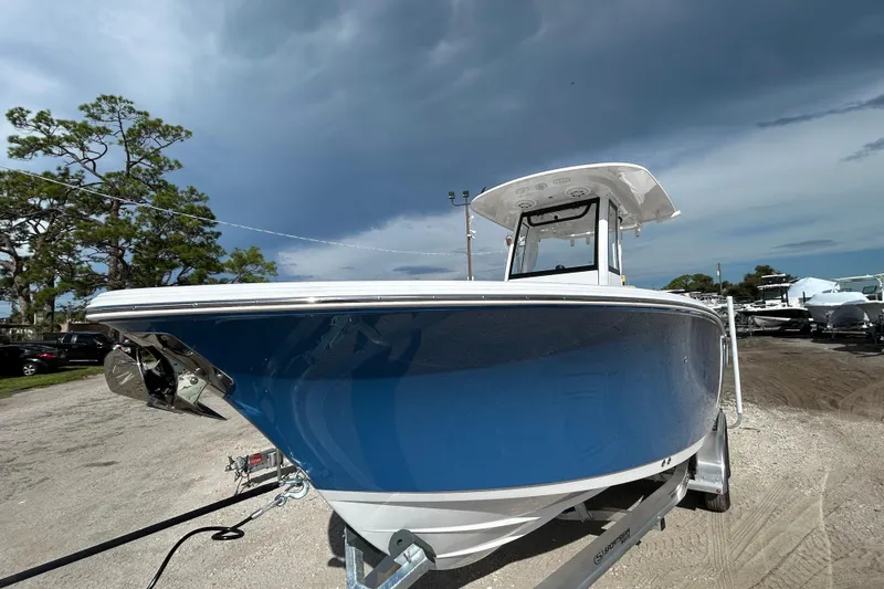 Slide: The Image of 2026 Sportsman Open 232 Center Console boat on trailer under cloudy sky. - 7