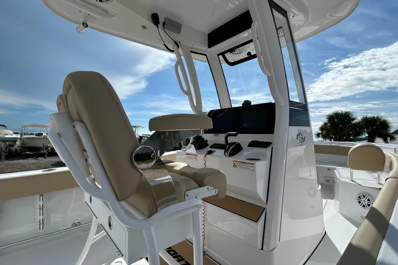 Slide: The Image of 2026 Sportsman Open 232 Center Console boat interior with helm and seating under blue sky. - 9
