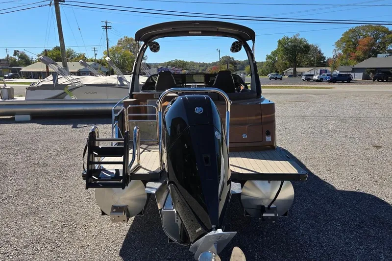 Slide: The Image of 2026 Avalon Platinum Catalina 2785 Elite Windshield boat with outboard motor, parked on gravel. - 5