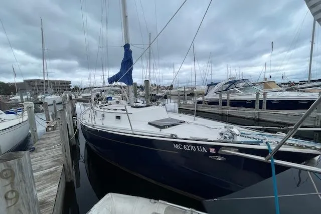 The Image of 1978 Hinterhoeller Niagra 35 sailboat docked at marina under cloudy skies. - 1