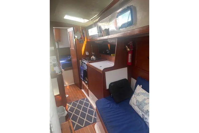 Slide: The Image of Interior of 1978 Hinterhoeller Niagara 35 Classic sailboat with cozy seating and kitchen area. - 21