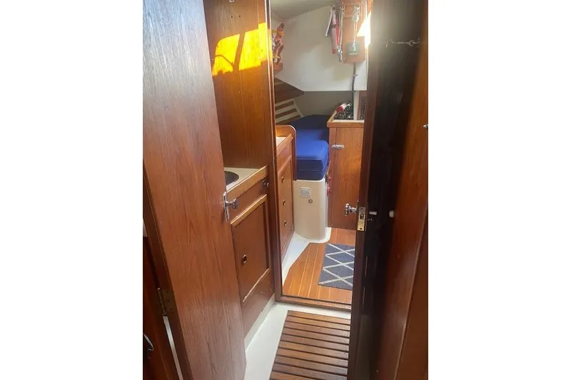 Slide: The Image of Interior of 1978 Hinterhoeller Niagara 35 Classic sailboat with wooden cabinetry and blue seating. - 27