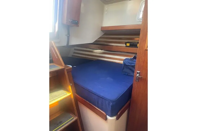 Slide: The Image of 1978 Hinterhoeller Niagara 35 Classic cabin with blue mattress and wooden interior. - 29