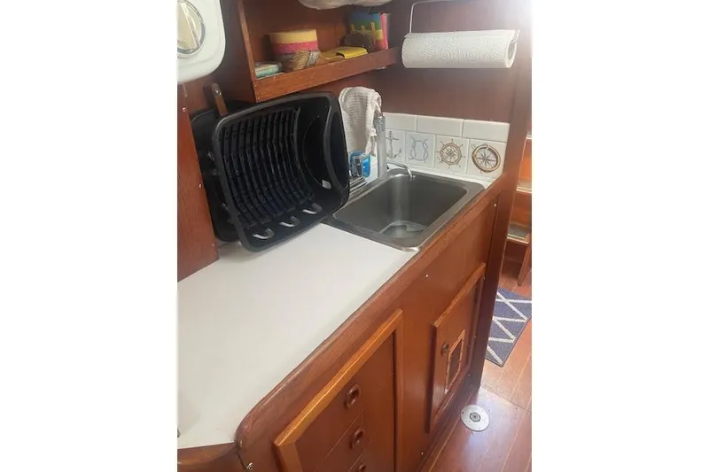 Slide: The Image of 1978 Hinterhoeller Niagara 35 Classic yacht kitchen with sink and wooden cabinetry. - 34
