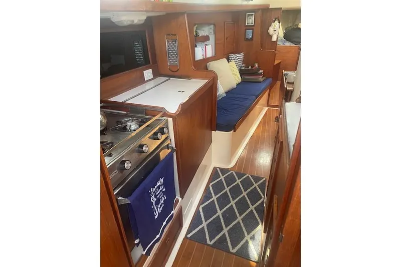 Slide: The Image of Interior of 1978 Hinterhoeller Niagara 35 Classic sailboat with cozy seating and kitchen area. - 38