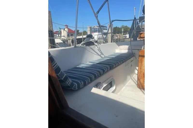 Slide: The Image of 1978 Hinterhoeller Niagara 35 Classic sailboat cockpit with striped cushions and wooden accents. - 6
