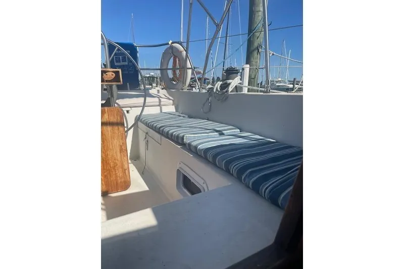 Slide: The Image of 1978 Hinterhoeller Niagara 35 Classic sailboat cockpit with striped cushions and wooden accents. - 7