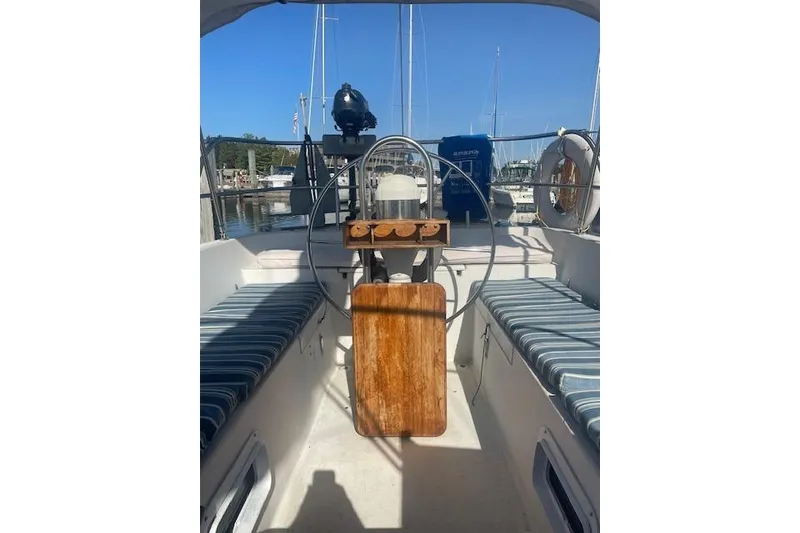 Slide: The Image of 1978 Hinterhoeller Niagara 35 Classic sailboat cockpit with striped seating and wooden table. - 8