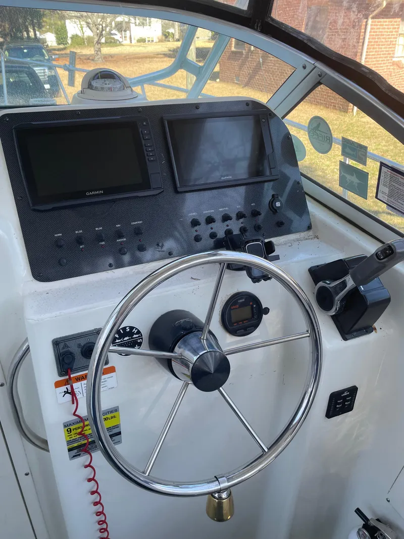 Slide: The Image of 2004 Hydra-Sports 230 WA boat dashboard with Garmin navigation screens and steering wheel. - 5