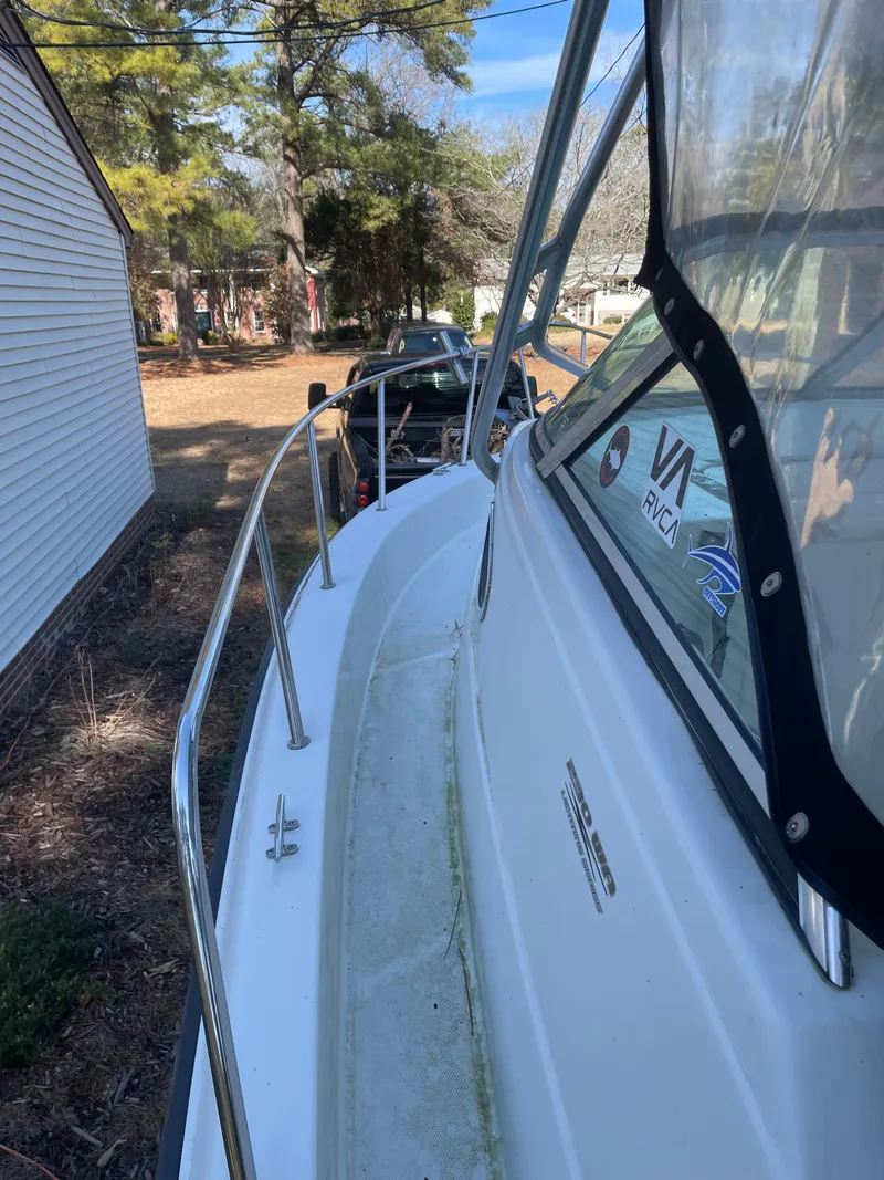 Slide: The Image of 2004 Hydra-Sports 230 WA boat docked beside a house with trees in the background. - 7