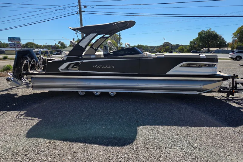 Slide: The Image of 2026 Avalon 2785 Excalibur LTD Windshield Quad Lounger boat in parking lot. - 4