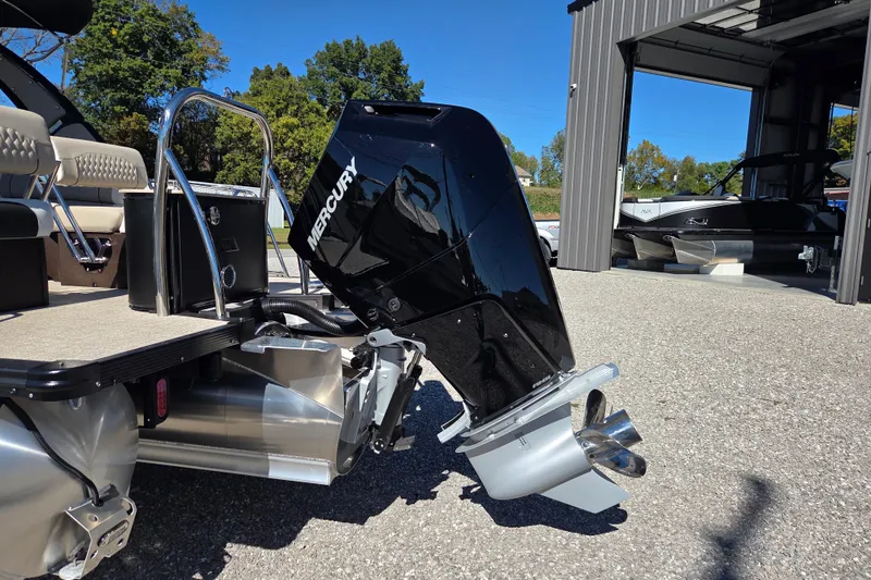 Slide: The Image of Avalon 2785 Excalibur LTD boat with Mercury engine, parked outside a garage, 2026 model. - 8