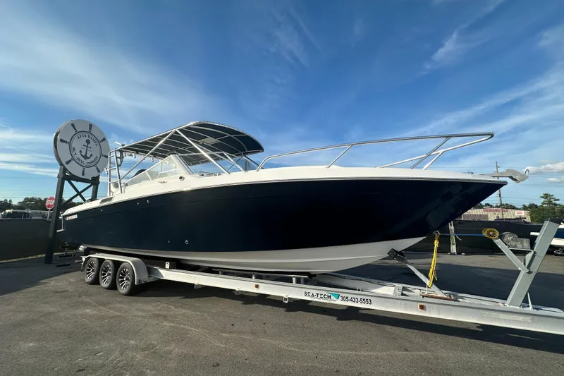 The Image of 2001 Contender 35 Side Console boat on trailer under clear blue sky. - 0