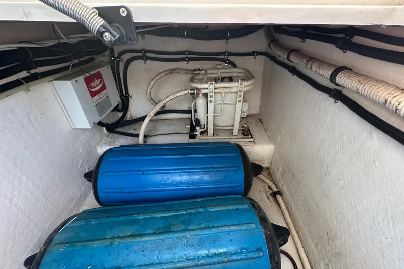 Slide: The Image of 2001 Contender 35 Side Console boat, white exterior, parked on pavement near road. - 52