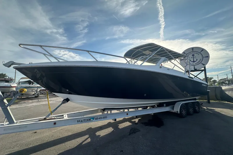 Slide: The Image of 2001 Contender 35 Side Console boat on trailer under cloudy sky. - 6