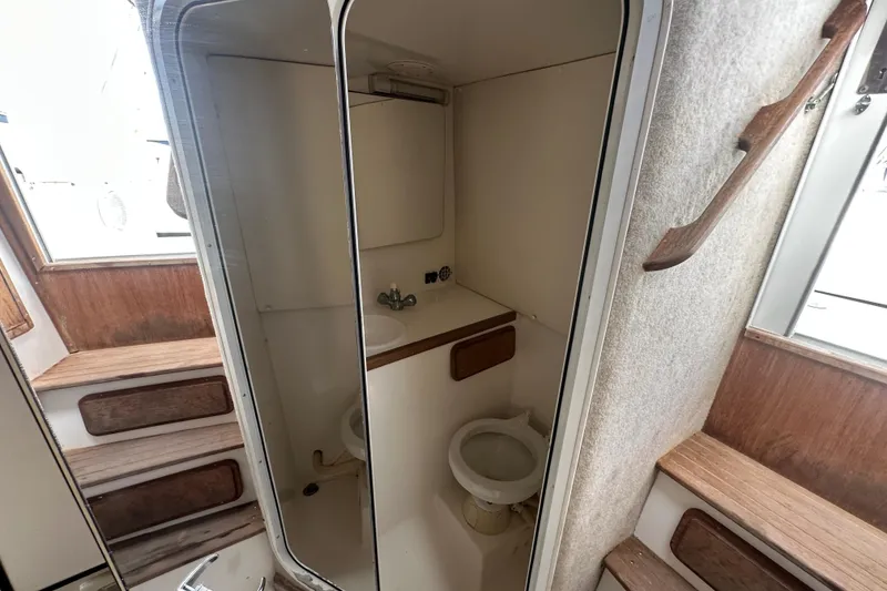 Slide: The Image of 2001 Contender 35 Side Console cabin interior with beige cushions and overhead hatch. - 64