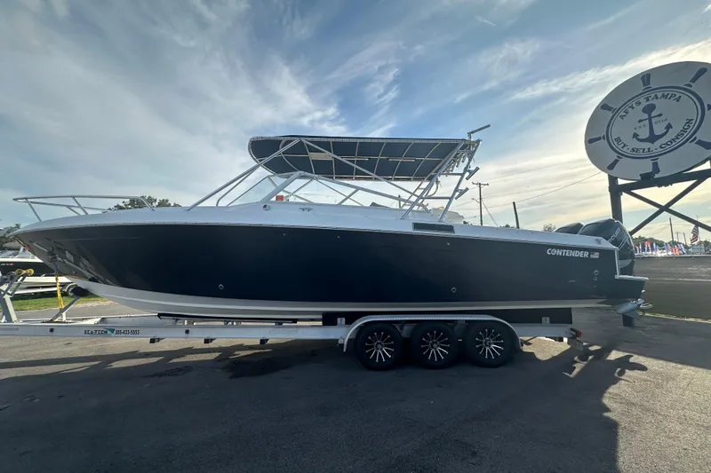 Slide: The Image of 2001 Contender 35 Side Console boat on trailer under cloudy sky. - 7