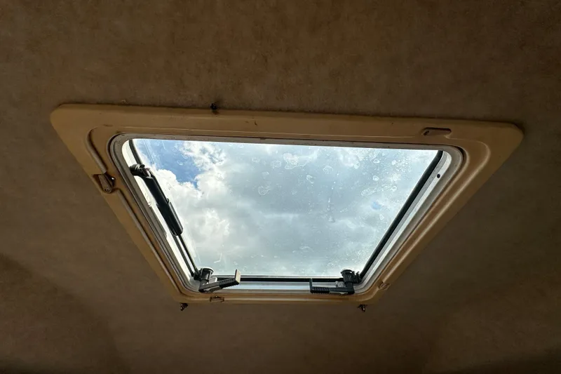 Slide: The Image of 2001 Contender 35 Side Console interior with kitchenette, sink, and seating area. - 75