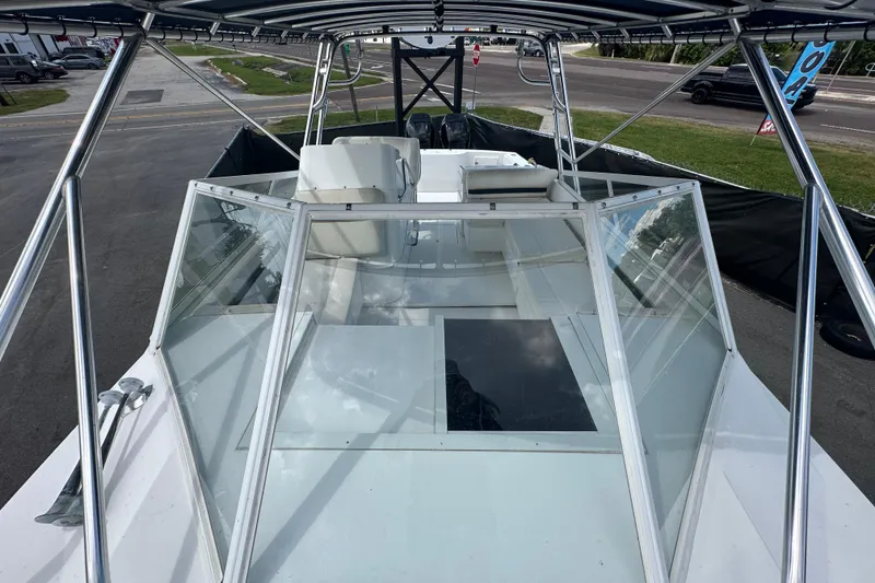 Slide: The Image of 2001 Contender 35 Side Console boat interior with seating and steering wheel, parked outdoors. - 86