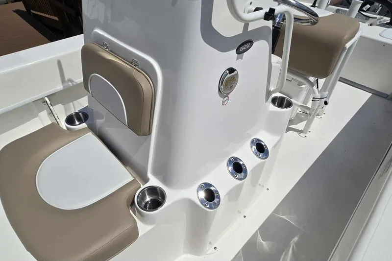 Slide: The Image of 2026 Sundance B22CCR boat interior with beige seating and cup holders. - 11