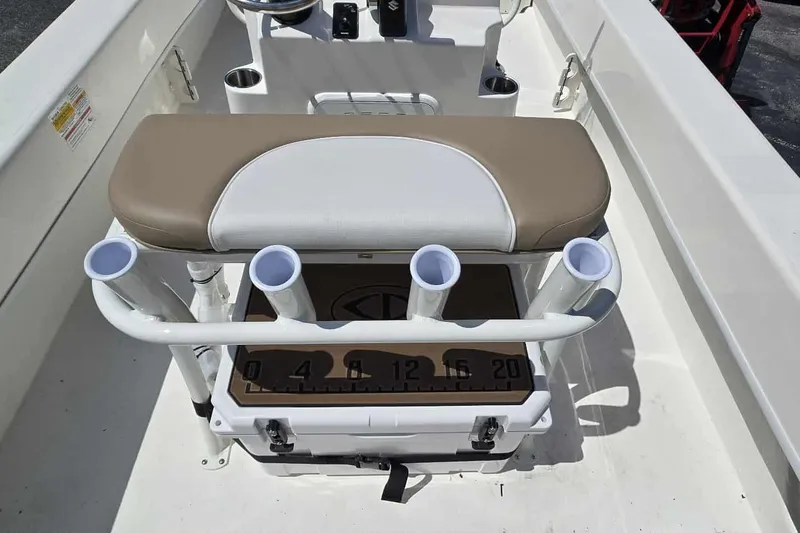 Slide: The Image of Interior of 2026 Sundance B22CCR boat with rod holders and cushioned seat. - 15