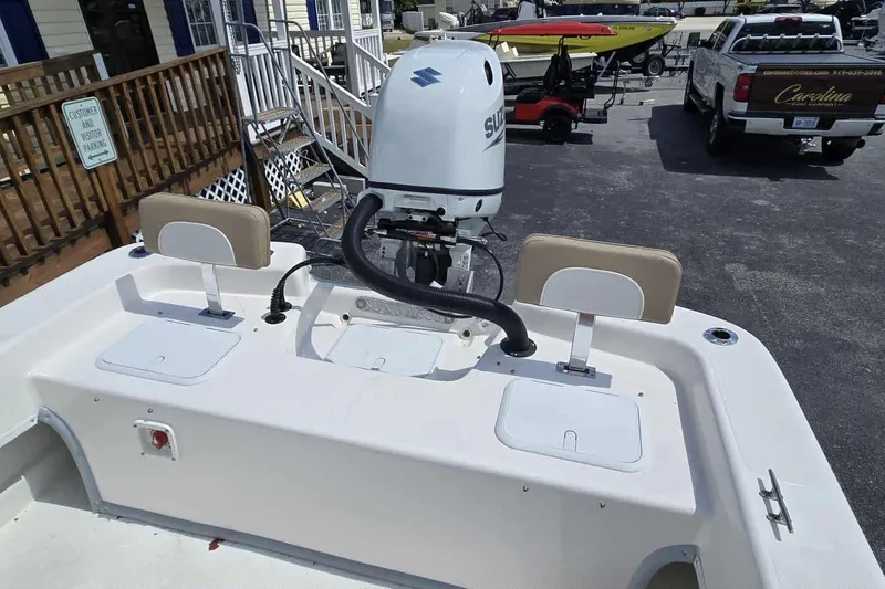 Slide: The Image of 2026 Sundance B22CCR boat with Suzuki outboard motor in a parking lot. - 18