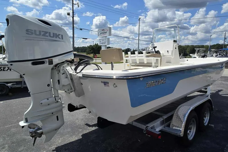 Slide: The Image of 2026 Sundance B22CCR boat with Suzuki outboard motor on a trailer, under a blue sky. - 5