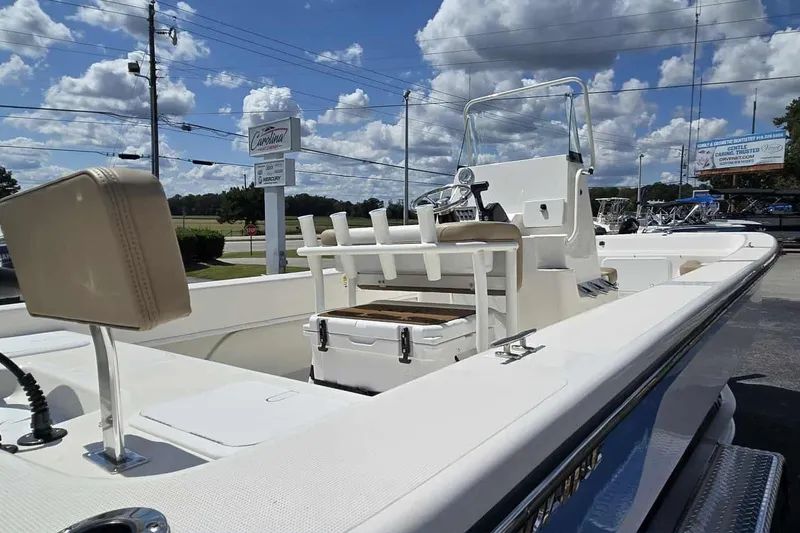 Slide: The Image of 2026 Sundance B22CCR boat with center console, parked outdoors under a cloudy sky. - 6