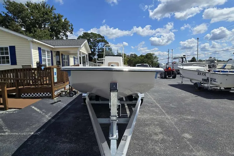Slide: The Image of 2026 Sundance B22CCR boat on trailer, parked outside a building under a blue sky. - 7