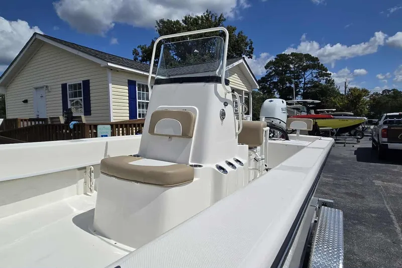 Slide: The Image of 2026 Sundance B22CCR boat with console, parked outdoors under a clear blue sky. - 9