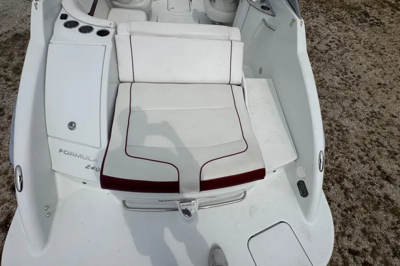 Slide: The Image of 2007 Formula 240 Bowrider boat with white seating and red trim, viewed from above. - 12