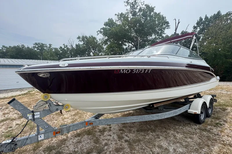 Slide: The Image of 2007 Formula 240 Bowrider boat on trailer, maroon and white, parked outdoors. - 2