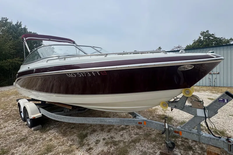 Slide: The Image of 2007 Formula 240 Bowrider boat on trailer, maroon and white, parked outdoors. - 3