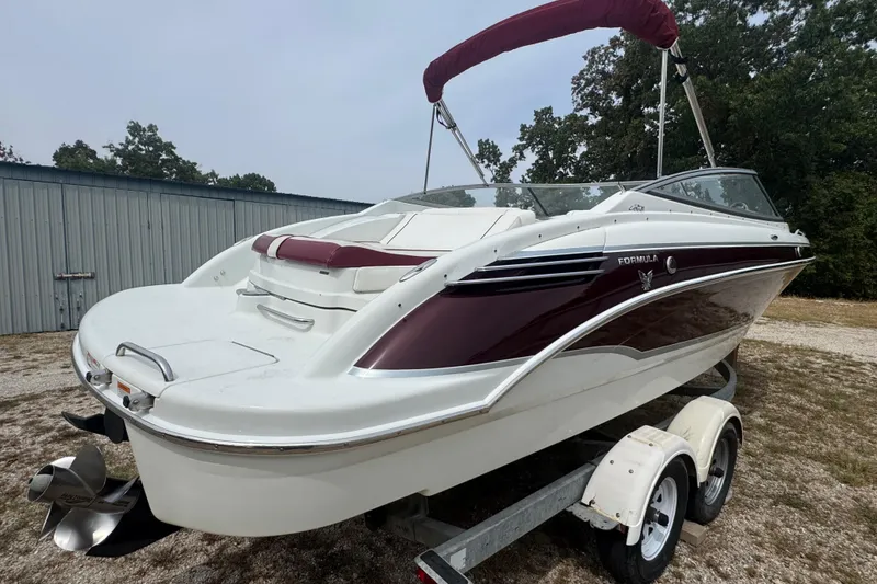 Slide: The Image of 2007 Formula 240 Bowrider boat on trailer, featuring maroon and white design. - 4