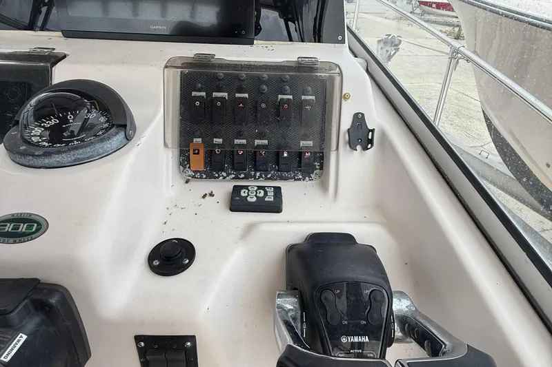 Slide: The Image of 2001 Grady-White Marlin 300 boat dashboard with compass and control panel. - 15