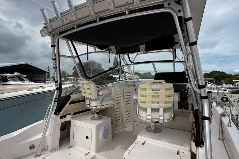 Slide: The Image of 2001 Grady-White Marlin 300 boat interior with helm and seating under cloudy skies. - 19
