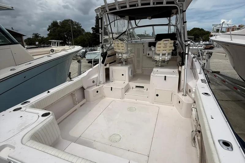 Slide: The Image of 2001 Grady-White Marlin 300 boat interior with seating and controls, docked outdoors. - 24