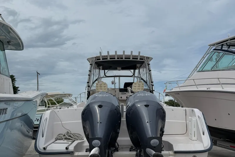 Slide: The Image of 2001 Grady-White Marlin 300 boat with dual outboard motors, docked under cloudy skies. - 7