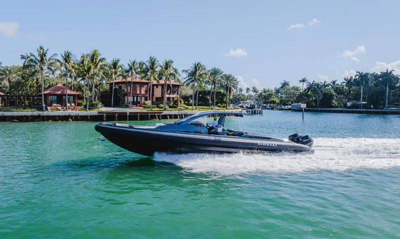 Slide: The Image of 2023 Pirelli Tecnorib 50 speedboat cruising on a tropical waterway with palm trees. - 21