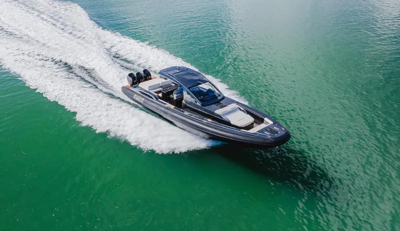 Slide: The Image of 2023 Pirelli Tecnorib 50 speedboat cruising on clear green water. - 3