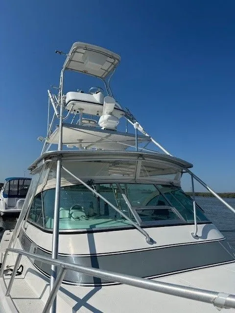Slide: The Image of 1987 Shamrock 31 GS boat with tower, docked under clear blue sky. - 28