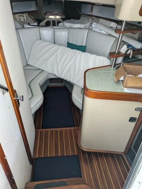 Slide: The Image of 1987 Shamrock 31 GS cabin interior with white seating and wooden flooring. - 3