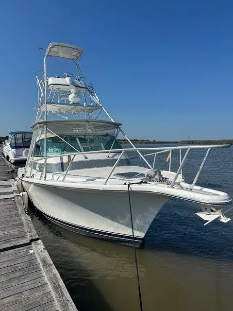 Slide: The Image of 1987 Shamrock 31 GS boat docked by the water on a clear day. - 4