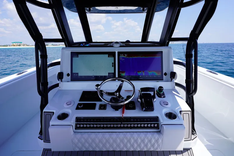 Slide: The Image of Helm of 2026 Invincible 40 Catamaran with advanced navigation displays and controls, on open sea. - 8