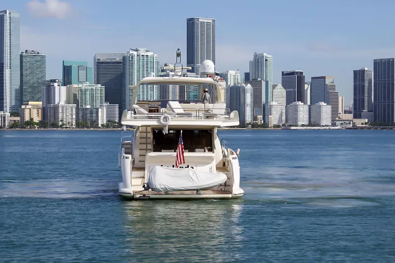 Slide: The Image of Azimut 70 yacht cruising near city skyline, 2011 model, with American flag displayed. - 4