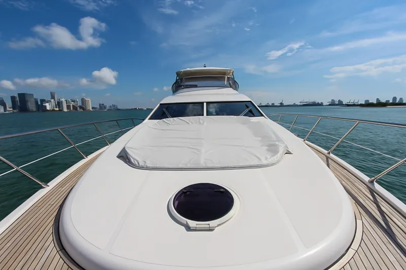 Slide: The Image of Luxury Azimut 70 yacht cruising on a sunny day, city skyline in background. - 49