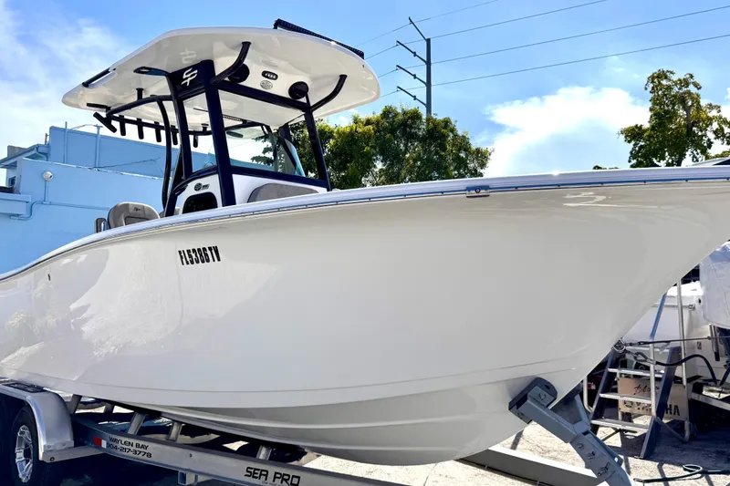 The Image of 2024 Sea Pro 242 boat on trailer, sleek design under clear blue sky. - 1