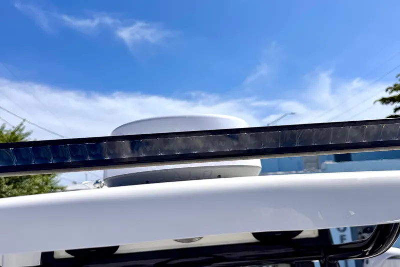 Slide: The Image of 2024 Sea Pro 242 boat detail with radar and light bar against blue sky. - 11