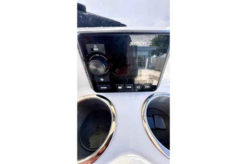Slide: The Image of 2024 Sea Pro 242 boat audio control panel with Audison system and cup holders. - 13