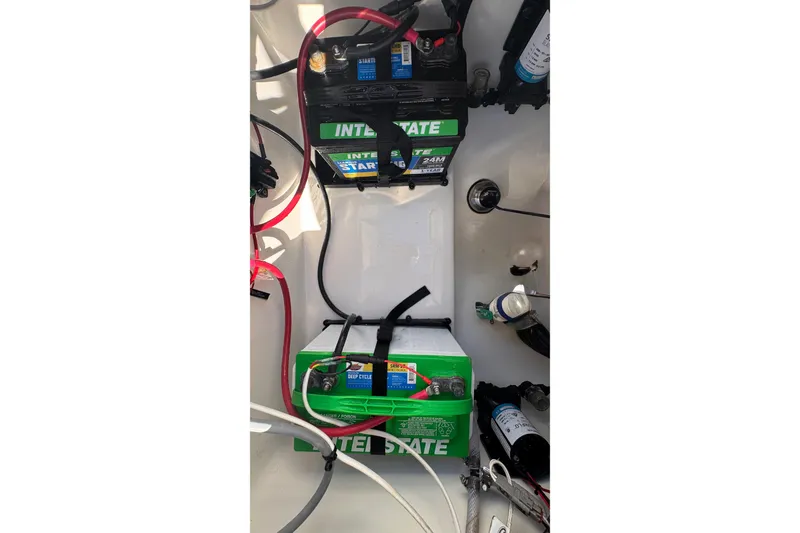 Slide: The Image of 2024 Sea Pro 242 boat battery compartment with Interstate batteries and wiring. - 22